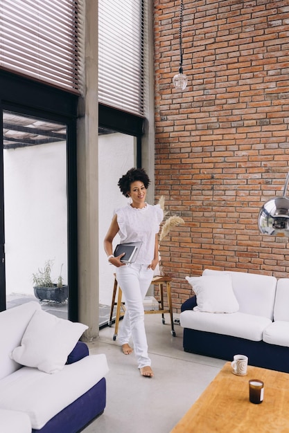 Foto zwarte vrouw loopt in een modern appartement met werkgereedschap