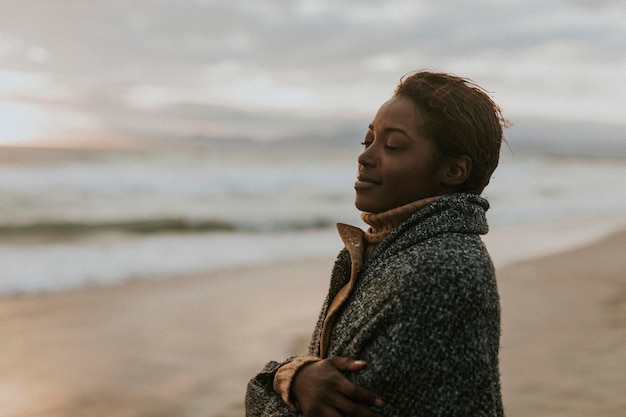 Zwarte vrouw op het strand bij zonsondergang