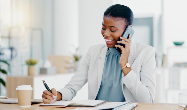 Zwarte vrouw telefoontje en schrijven in boekconsultatie voor financieel advies gesprek of communicatie op kantoor Gelukkig Afrikaanse vrouwelijke accountant praten op smartphone gegevens op de computer controleren