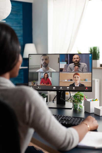 Zwarte vrouw zit aan bureau en werkt op afstand aan marketingcursusideeën