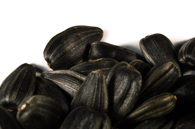 Zwarte zonnebloempitten in macro geïsoleerd op witte achtergrond Voedsel foto met textuur close-up