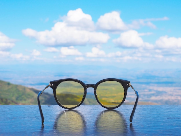 Zwarte zonnebril met gele lens op houten tafel