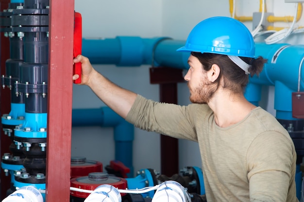 Zwembad reinigingssysteem kamer. professionele service en onderhoud van de zwembadwaterpomp. technicus man aan het werk.