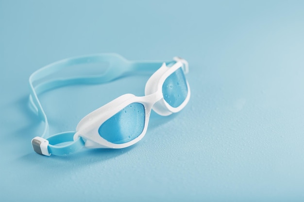 Foto zwembril in een wit frame met op een blauw