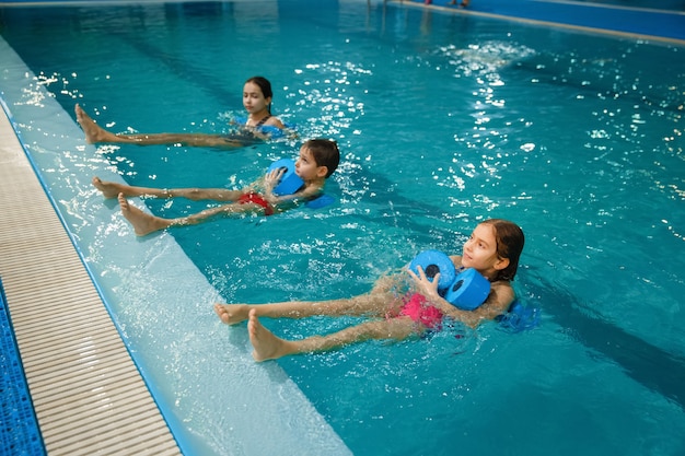 Zwemgroep voor kinderen, trainen met halters in het zwembad