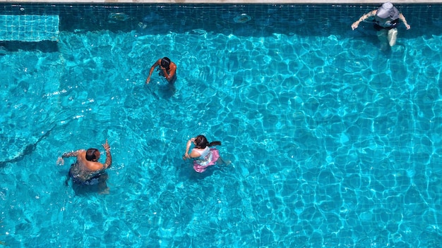 Zwemmen in het hotelzwembad en blauw helder kleurwater in de zomer en bovenaanzicht.