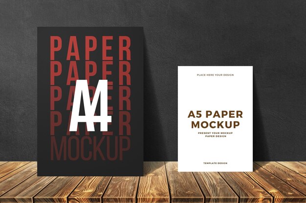 PSD a4 and a5 size paper mockup with leaning on dark texture background