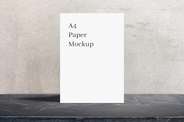 A4 paper mockup leaned on grey wall texture