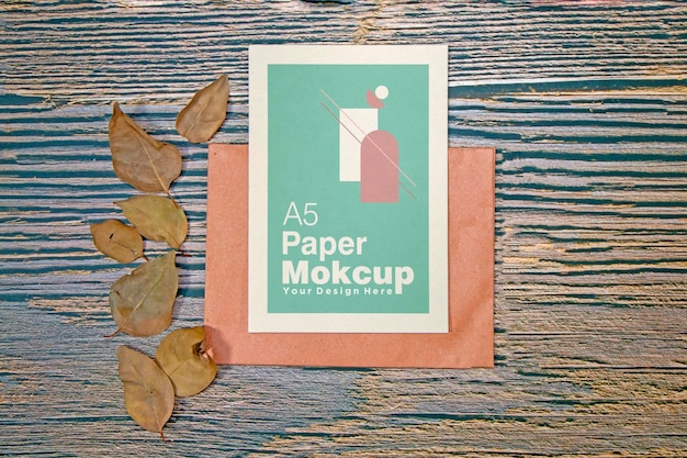 Бумажный макет поздравительной открытки формата а5 с сухими листьями на деревянном фоне
