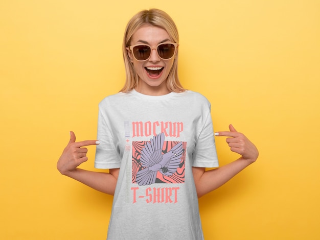 Aanzicht van een vrouw die een t-shirt mock-up ontwerp draagt en ernaar wijst