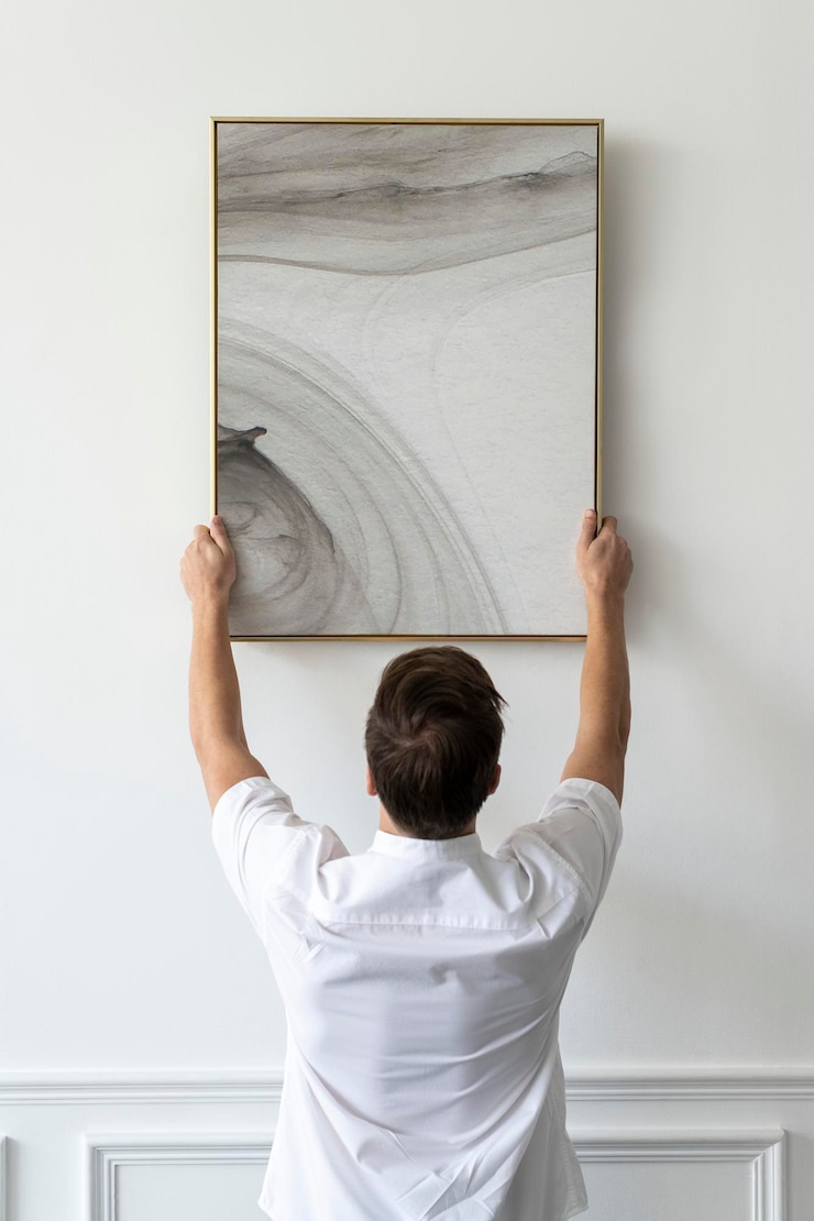 PSD abstract painting frame psd being hung by a young man on a white minimal wall