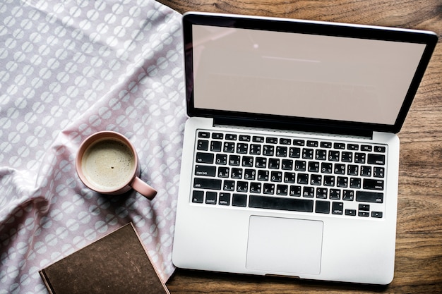 aerial view of computer laptop on wooden table and a cup of hot milk