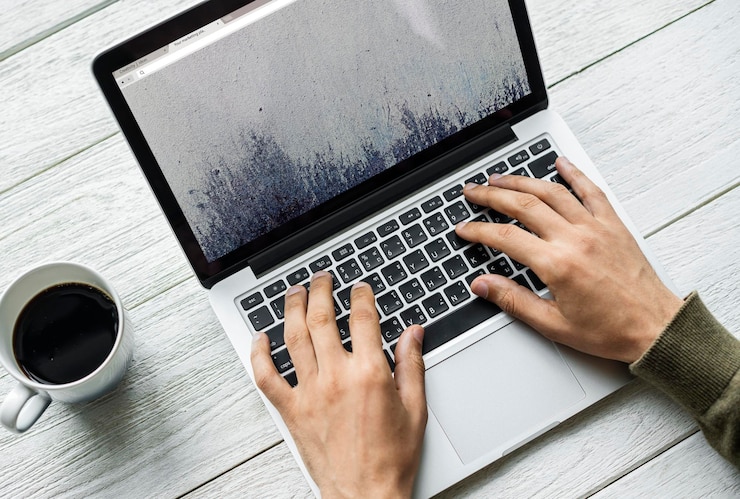 PSD aerial view of a man using computer laptop on wooden table