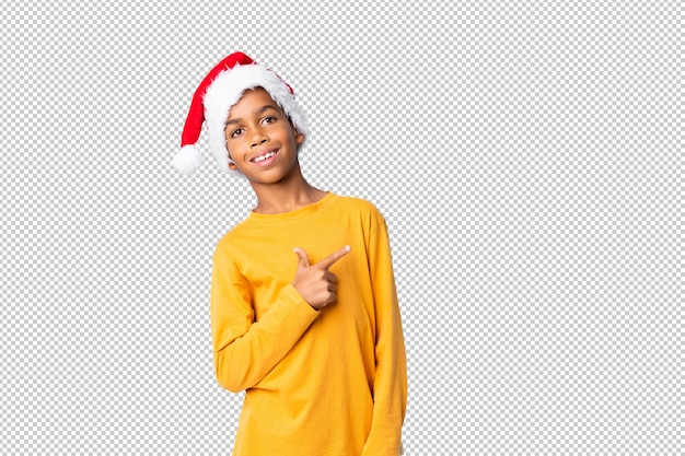 Афро-американский мальчик в шляпе рождество, указывая на сторону, чтобы представить продукт