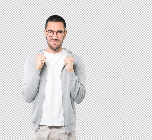 Angry young man posing against transparent surface