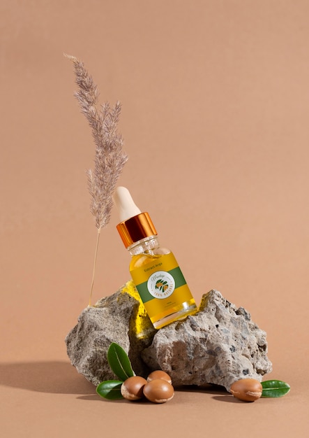 PSD mock-up di bottiglia cosmetica all'olio di argan con noccioli e contagocce