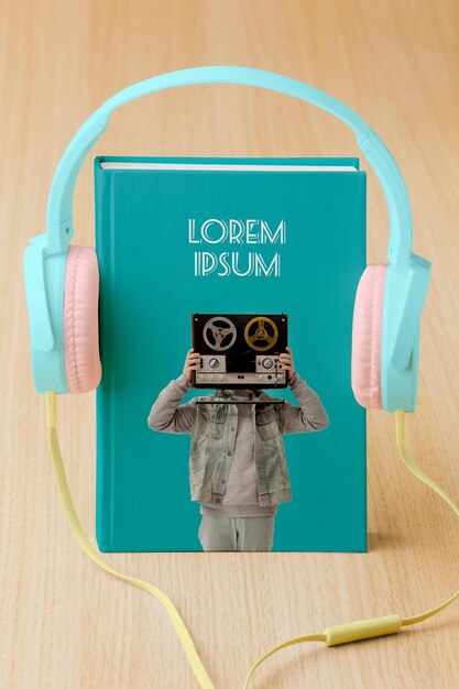 Arrangement with book cover mock-up and headphones