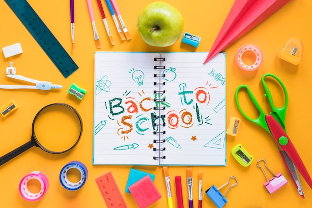 Arrangement with school supplies and opened notebook