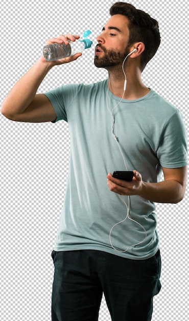athletic young man drinking water and listening to music