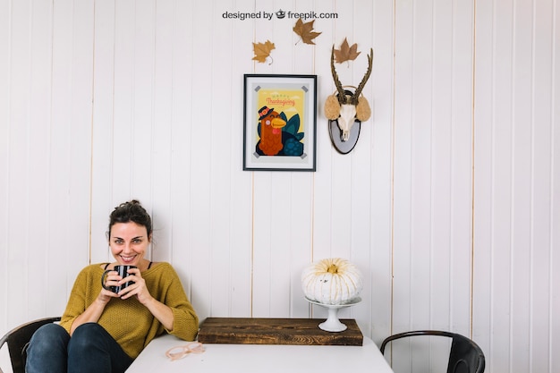 Mockup di autunno con la tazza della holding della donna