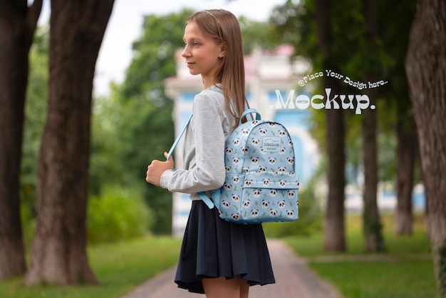 バックパックのモックアップを背負った学生が学校に戻る