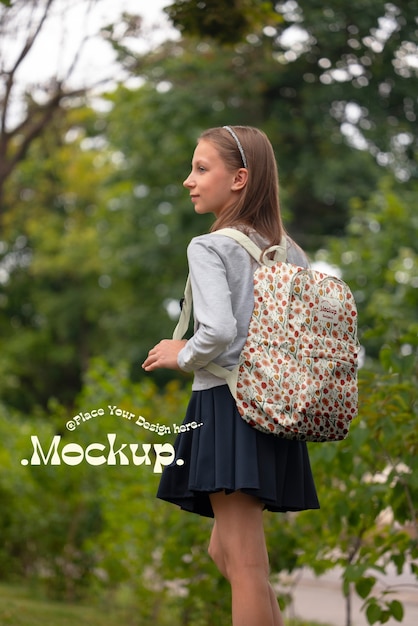 バックパックのモックアップを背負った学生が学校に戻る