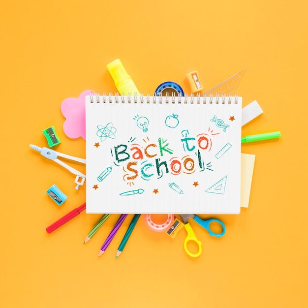 Back to school supplies on yellow background