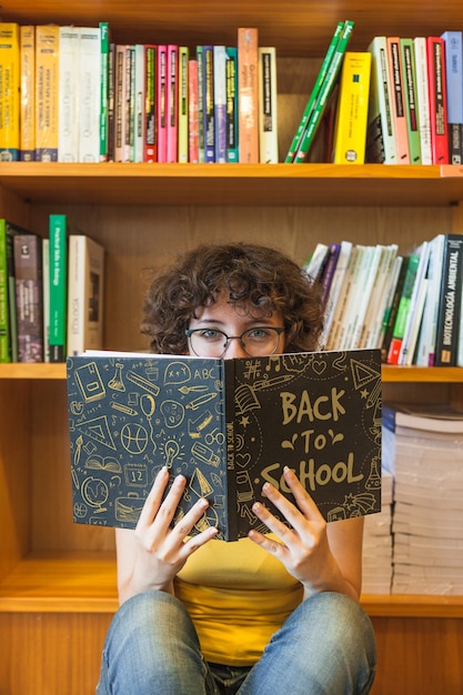 PSD Вернуться в школу концепции с книгой чтения девочки в библиотеке