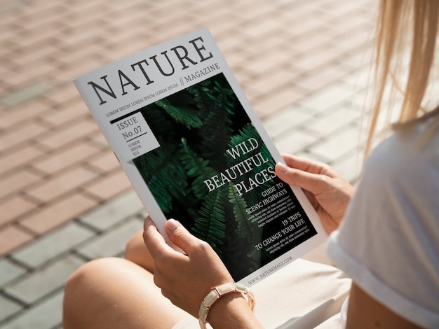 Back view hands holding nature magazine mock up