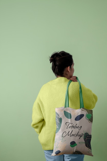 Back view of person carrying tote bag mock-up