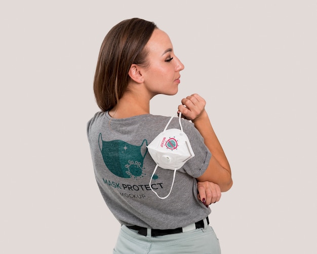 Back view of woman holding mask over her shoulder