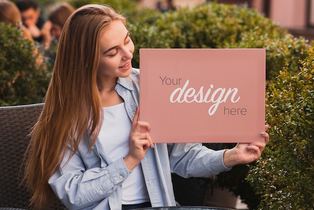 PSD beautiful girl holding a banner mock-up