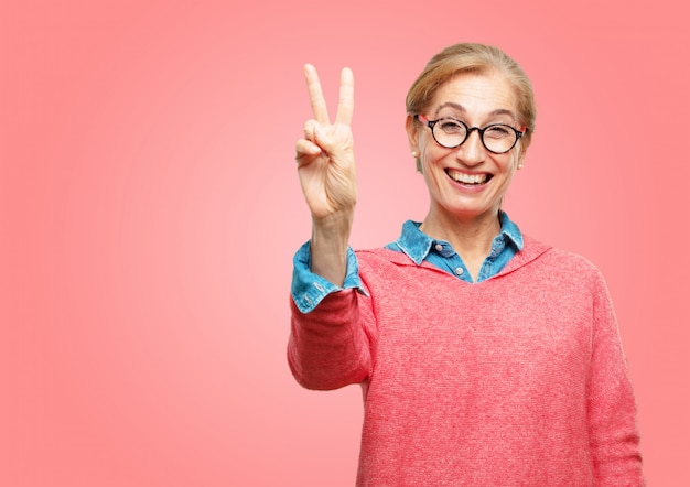 Bella donna senior con un'espressione fiera, felice e sicura; sorridendo e mostrando il successo