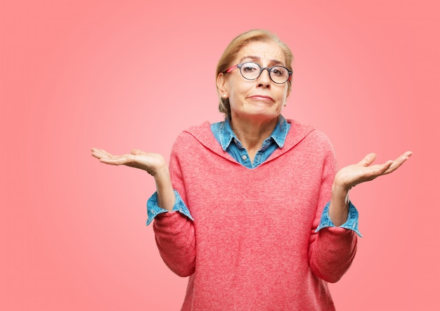 Beautiful senior woman with a quizzical and confused look, doubting between different choices