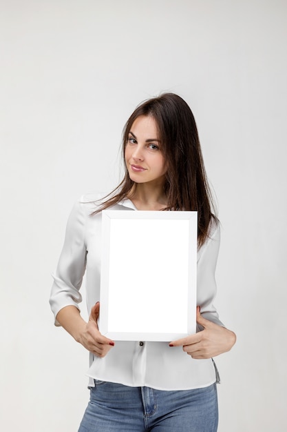 PSD beautiful smiling woman holding blank board