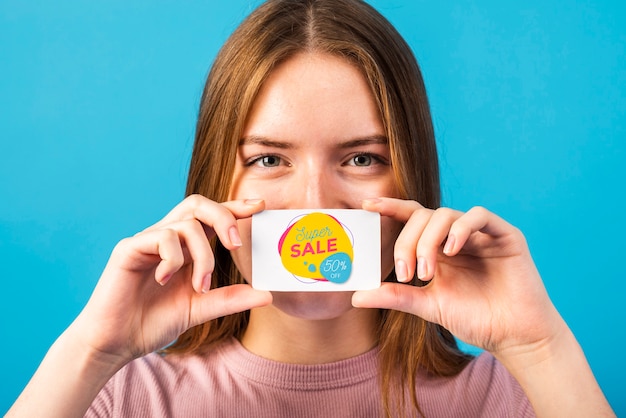 Beautiful woman holding a super sale coupon