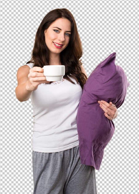 一杯のコーヒーを保持している枕を持つ美しい少女