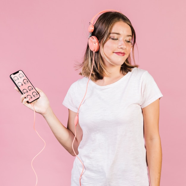 PSD beautiful young woman with headphones and a cellphone mock-up