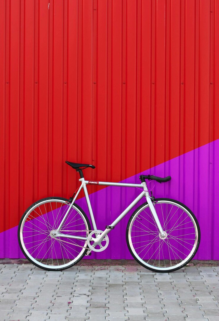PSD a bike is leaning against a wall with a purple wall behind it