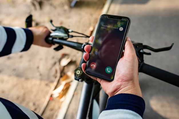 Motociclista che tiene smartphone con chiamata in arrivo