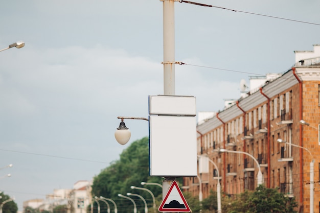 Bilbard z wielobarwną reklamą i oświetleniem stoi na ulicy w świetle dziennym, zdjęcie poniżej