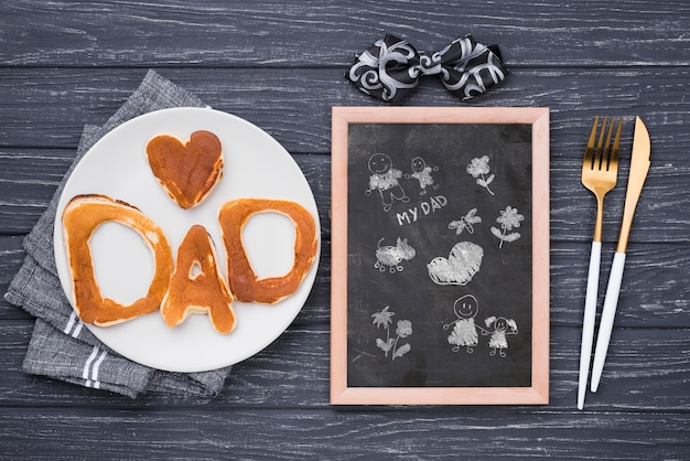 Blackboard with pancakes and cutlery for fathers day