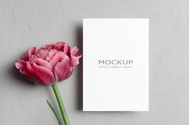 PSD blank card mockup with fresh tulip flower on grey background