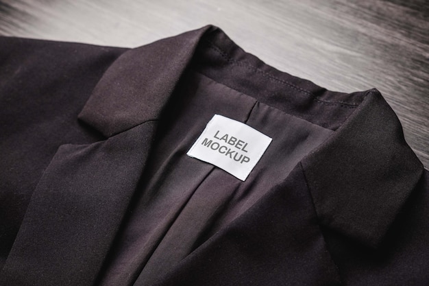 Blank clothing tag on the texture of a black blazer Label with empty space for text