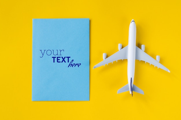 Blank greeting card mockup with airplane toy. summer travel concept.