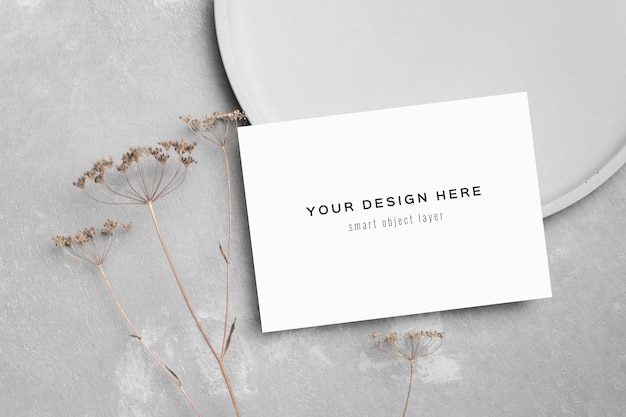 회색에 봉투와 마른 꽃 장식이 있는 빈 초대 카드 모형
