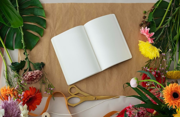 PSD blank notebook mockup among colorful flowers