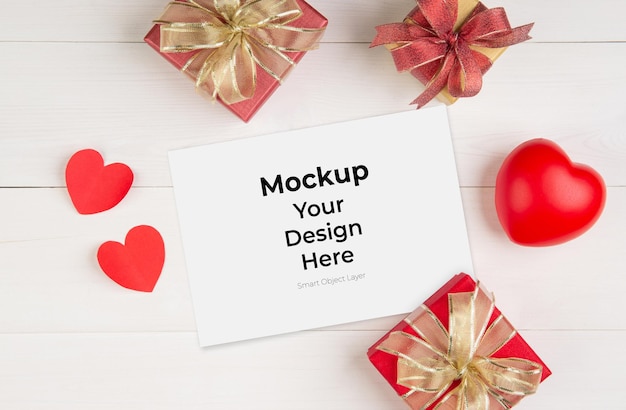 Blank postcard and gift box and heart shape on wooden table