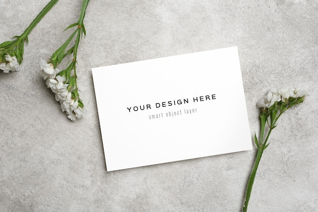PSD blank uitnodigingskaart mockup met bloemen op stenen achtergrond bovenkant met kopieerruimte
