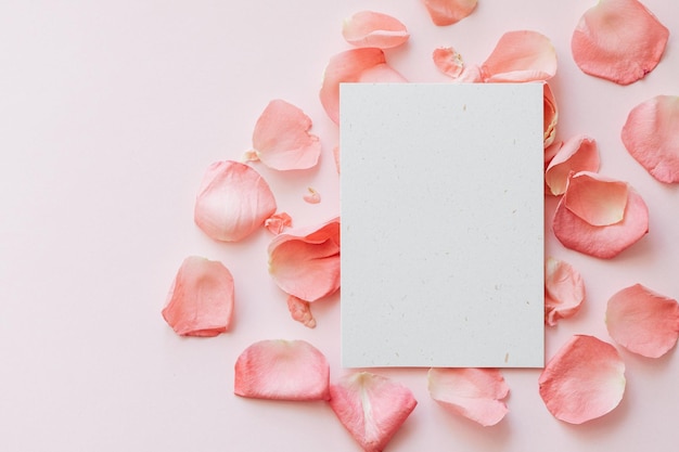 PSD blanke verticale uitnodiging of groetekaartje met lichtroze achtergrond en roze roosblaadjes